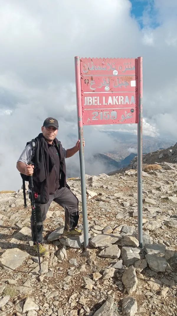 Le guide de montagne Imad Ben Yahya au panneau du sommet du Jbel Lakraa, 2159 m